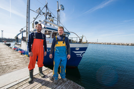 Un bateau et les fondateurs de Chasse-Marée, entreprise locale de Rimouski qui offre des produits de la mer et de la pêche provenant du fleuve Saint-Laurent.